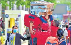  ??  ?? ■
Railway porters carry luggage of passengers arriving at a railway station to board a special train to New Delhi in Bengaluru; an elderly person heads to board a train to Delhi at Howrah junction; and people exit the station after arriving at Jabalpur on Tuesday.