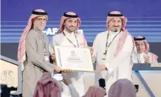  ?? — AFP ?? AFC President Salman bin Ibrahim al Khalifa (L) presents Saudi Arabia’s Minister of Sports and Youth Abdulaziz bin Turki al Faisal al Saud (C) with a plaque, appointing Saudi Arabi as the host of the 2027 AFC Asian Cup, during the 33rd AFC Congress at the Gulf Convention Centre in Manama on Wednesday.