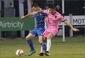  ??  ?? Ricky Fox gets in a challenge on Waterford striker Mark O’Sullivan.