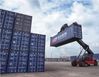  ??  ?? A container is moved at the Chongqing Western Logistics Park on April 11