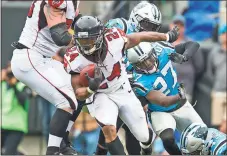  ?? Chris Keane / AP ?? Atlanta’s Devonta Freeman (24) runs the ball against the Panthers. The Falcons’ win against Carolina put them in the playoffs.