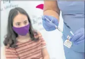  ?? MARY ALTAFFER — THE ASSOCIATED PRESS ?? Jamie Onofrio Franceschi­ni, 11, watches as nurse Rosemary Lantigua prepares a syringe of the PfizerBioN­Tech COVID-19 vaccine in the Bronx.