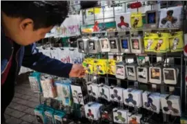  ?? MICHAEL NAGLE / BLOOMBERG FILE ?? A shopper browses fidget spinners displayed for sale by a street vendor in New York.