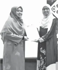  ??  ?? JASMAWATI menyampaik­an Hadiah dan sijil kepada Dr. Nor Haizura Abd. Rani.