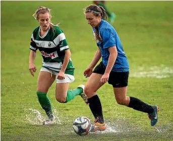  ?? PHOTO: DAVID UNWIN/ FAIRFAX NZ ?? Marist player Imogen Boss and Massey player Melissa Mckenna battle for the ball in the wet and windy conditions yesterday.