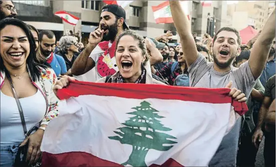  ?? PATRICK BAZ / AFP ?? Después de los enfrentami­entos, la alegría estalló en las calles de Beirut al conocerse la renuncia del primer ministro