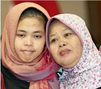  ?? — AP ?? Siti aisyah, left, hugs her mother Benah after a press conference at the foreign minister’s office in jakarta on Monday.