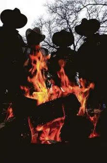  ?? Staff file photo ?? Members of Sam Houston Trail Riders keep warm around a fire while at Memorial Park in Houston in 2003.