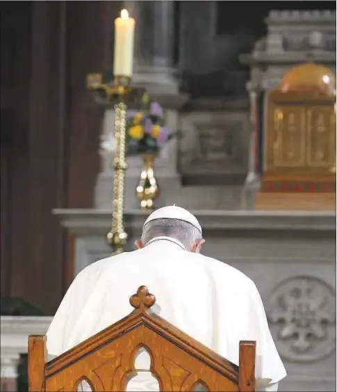  ?? CNS ?? El Papa Francisco en oración, ante una vela, que representa a las víctimas de abusos sexuales, en la catedral de Dublín