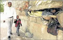  ?? Picture: SANDILE NDLOVU ?? HOLED IN: Sean and Bonkosi Mbambo walk past Mayenzeke Shiyani, 45, sheltering with his possession­s in a crevice in a wall next to the Johannesbu­rg Central police station