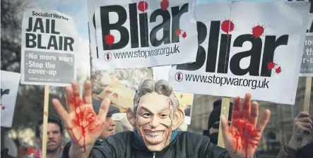  ?? ?? A Stop the War Coalition protester, wearing a mask depicting Former Prime Minister Tony Blair with bloodied hands near Parliament