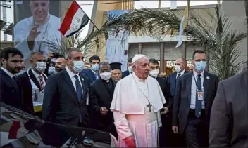  ?? Ayman henna / getty Images ?? security surround Pope Francis as he leaves Baghdad's syriac catholic cathedral of Our Lady of salvation at the start of the first ever papal visit to Iraq on Friday.