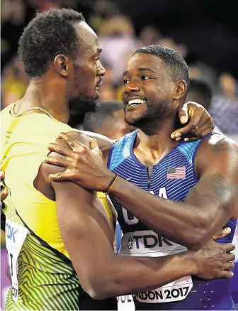  ?? Třetí Usain Bolt (vlevo) v objetí s vítězným Justinem Gatlinem. Sesazený král sprintu Gatlinovi v těchto chvílích mimo jiné říkal, že bučení, které jeho triumf provázelo, si nezaslouží. FOTO REUTERS ?? V cíli.