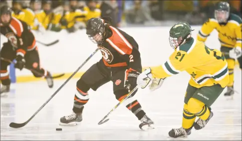  ?? H John Voorhees III / Hearst Connecticu­t Media ?? Ridgefield’s Nicky Cullinan and Hamden’s Benjamin Chicoine battle for the puck during the Tigers’ 6-1 victory on Saturday in Hamden.