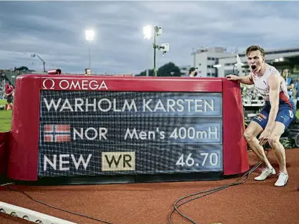  ?? FREDRIK HAGEN / AP ?? Warholm posa amb la pantalla que mostra el seu rècord del món de 400 m tanques aconseguit a Oslo