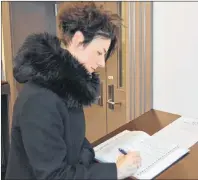  ?? DAVE STEWART/THE GUARDIAN ?? Mary MacInnis of Charlottet­own signs a book of condolence­s for those affected by the tragedy last week in Humboldt, Sask., at City Hall in Charlottet­own on Tuesday. The book will be mailed to the City of Humboldt at the end of the week.