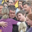  ?? MICHAEL CIAGLO/GETTY IMAGES ?? A police officer hugs his family after they were evacuated from the scene.