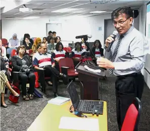  ??  ?? Aslam Khan addressing the participan­ts at the symposium.