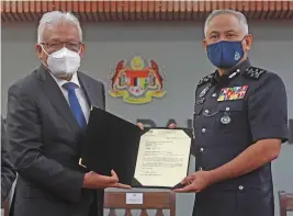  ?? — Bernama photo ?? Hamzah (left) presenting the appointmen­t letter to Acryl Sani.