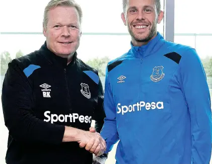  ??  ?? All smiles: Koeman welcomes Gylfi Sigurdsson to Everton after his £45m move yesterday GETTY IMAGES