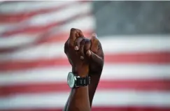  ?? AP Photo/David Goldman, File ?? ■ People join hands against the backdrop of an American flag on June, 21, 2015, as thousands of marchers meet in the middle of Charleston’s main bridge in a show of unity after nine black church parishione­rs were killed by Dylann Roof during a Bible study in Charleston, S.C. For many Black Americans, the shooting at a supermarke­t on Saturday in Buffalo, N.Y., has stirred up the same feelings they faced after Charleston and other attacks: the fear, the vulnerabil­ity, the worry that nothing will be done politicall­y or otherwise to prevent the next act of targeted racial violence.