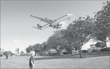  ?? Gina Ferazzi
Los Angeles Times ?? NOAH MOSS, 3, of Maui plays on the grass near LAX on Monday as a plane prepares to land at one of the north runways. The airport agency wants to move the northernmo­st runway 260 feet closer to Westcheste­r.