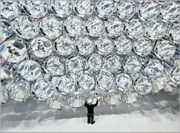  ?? CAROLINE SEIDEL/DPA ?? Engineer Volkmar Dohmen examines xenon short-arc lamps this week at the German Aerospace Center in Juelich, near Cologne. The 149 spotlights simulate natural sunlight.