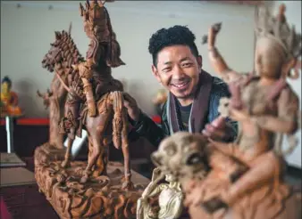  ?? XINHUA ?? A Tibetan trainee shows his clay works at a traditiona­l sculpture exhibition in the Tibet autonomous region on Wednesday, after just one month of training. The program included learning about intangible cultural heritage.