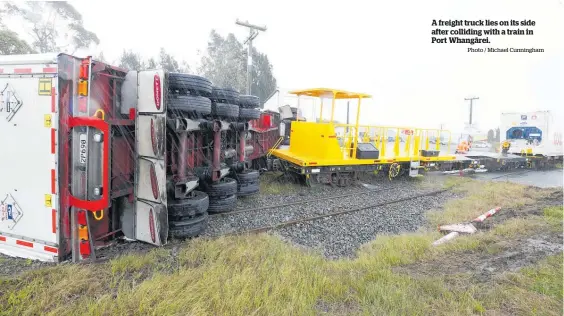  ?? Photo / Michael Cunningham ?? A freight truck lies on its side after colliding with a train in Port Whangārei.