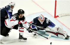  ?? AP Photo/Petr David Josek ?? ■ Keith Kinkaid, right, and Johnny Gaudreau, left, of the U.S. make a save against Canada’s Joshua Bailey, center, during the Ice Hockey World Championsh­ips group B match Friday at the Jyske Bank Boxen Arena in Herning, Denmark.