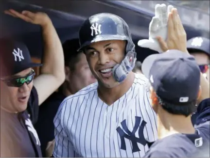  ?? SETH WENIG — THE ASSOCIATED PRESS ?? New York Yankees’ Giancarlo Stanton is greeted in the dugout after hitting a solo home run during the first inning of a baseball game against the Texas Rangers at Yankee Stadium Sunday in New York.