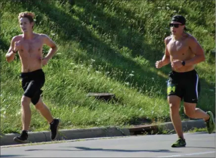  ?? JON BEHM - THE MORNING JOURNAL ?? Journal Jog winner Sam McClelland, left, holds a narrow lead over Alex Radanovich, who finished second overall. McClelland won the race with a time of 18:02.7.