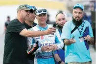  ?? (AP Photo/john Raoux) ?? Fans takes selfie photos with Kevin Harvick, center, in the garage area Feb. 17 during a practice session for the NASCAR Daytona 500 auto race at Daytona Internatio­nal Speedway, in Daytona Beach, Fla.