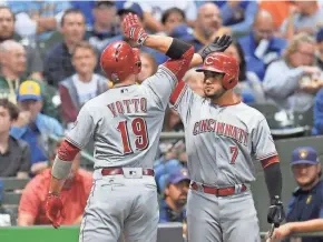  ?? GETTY IMAGES ?? Joey Votto is congratula­ted by Eugenio Suarez after his homer a solo home run put the Reds up, 1-0, in the first inning.