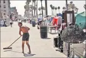  ?? Genaro Molina Los Angeles Times ?? DAVID CRUZ, 55, who is homeless, sweeps Ocean Front Walk near a row of encampment­s in Venice.