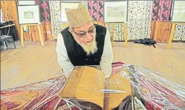  ?? WASEEM ANDRABI/HT ?? A visitor looks at the Quranic manuscript on display at the Tourist Reception Centre in Srinagar on Saturday.