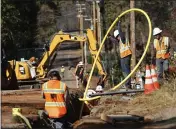  ?? RICH PEDRONCELL­I — AP PHOTO, FILE ?? Pacific Gas & Electric Company workers bury utility lines in Paradise. People who lost family members, homes and businesses in California wildfires had a Tuesday deadline to seek compensati­on.