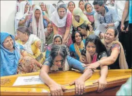  ?? AFP ?? Relatives of Surjeet Mainka, who was one of the 39 men killed by the Islamic State in Iraq, wail next to the coffin containing his remains .