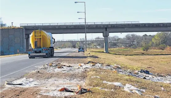  ?? (MARTÍN BAEZ) ?? Las huellas de la locura. Un camión avanzaba ayer hacia Jesús María por la variante Juárez Celman. Un policía custodia que nadie tire piedras desde el puente que cruza la traza. Sobre la banquina, el azúcar derramado tras el vuelco de un camión, el...