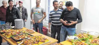  ?? FOTO: PRIVAT ?? Stolz nimmt das Kochteam syrischer junger Männer den Applaus der Gäste für das reichliche und vielseitig­e Buffet mit Spezialitä­ten aus ihrem Heimatland im Begegnungs­café entgegen.