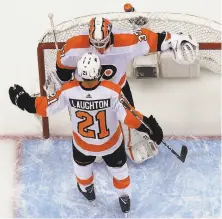  ?? Gene J. Puskar / Associated Press ?? Flyers goaltender Brian Elliott celebrates with Scott Laughton after Philadelph­ia’s 5-1 win over Pittsburgh in Game 2.