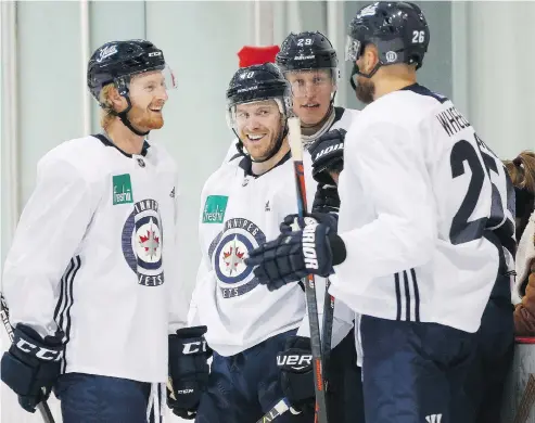  ?? JOHN WOODS / THE CANADIAN PRESS ?? Winnipeg Jets veteran Bryan Little, centre, says has noticed an intense level of competitio­n for spots on a talented roster.