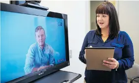  ?? JENNIFER ROBERTS/Postmedia News ?? Christine Sutch, Intake Coordinato­r for the Tele-Link Mental Health Program at Sick Kids
Hospital, with her colleague Alex Wells, uses the new video conferenci­ng system.