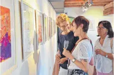  ?? FOTO: RUTH-MARIA SCHWAMBORN ?? Farbenprac­ht trifft auf Kreativitä­t: Bei der Ausstellun­g in der Oberteurin­ger Mühle kommen die Künstler mit den Gästen in Kontakt und erklären ihnen die Werke.