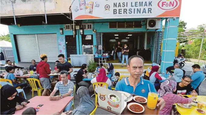  ?? PIC BY FATHIL ASRI ?? Nasi Lemak Bersinar owner Azeman Mat Jusoh with a tray of his popular nasi lemak outside his shop in Kota Baru.