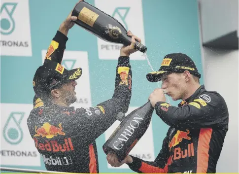  ??  ?? 0 Max Verstappen, right, celebrates on the podium with Red Bull team-mate Daniel Ricciardo after his victory in Penang.