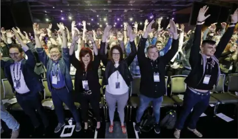  ?? ELAINE THOMPSON — THE ASSOCIATED PRESS ?? Participan­ts attending the keynote address at Microsoft’s Build, the company’s annual conference for software developers, are led in standing and stretching mid-way through the morning event Monday in Seattle.