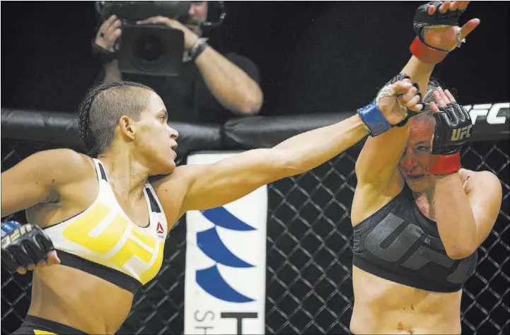  ?? ERIK VERDUZCO/LAS VEGAS REVIEW-JOURNAL / FOLLOW @ERIK_VERDUZCO ?? Challenger Amanda Nunes, left, of Brazil fires a punch as Miesha Tate covers up during the first round of their women’s bantamweig­ht title bout at UFC 200 on Saturday night at T-Mobile Arena. Nunes became the latest woman to take her turn as...