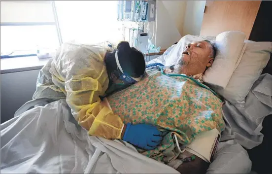  ?? Photograph­s by Francine Orr Los Angeles Times ?? ANA ZUÑIGA DIAZ hugs her 57-year-old father, Mariano Zuñiga Anaya, moments after he died on Feb. 6. As his vitals fell, she stroked his cheek and tucked him in.