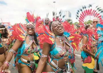  ?? TIJANA MARTIN/THE CANADIAN PRESS ?? Feathered and beaded participan­ts perform Saturday during the Grand Parade at the Caribbean Carnival in Toronto. The annual event resumed in the city after a two-year hiatus due to the COVID-19 pandemic.